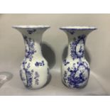 A pair of 19th century Delft style vases printed in blue and white with reserves of waterside