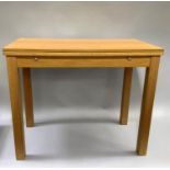 A pale oak draw leaf dining table on square legs, 90cm wide x90cm open