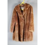 A tan full length fur coat labelled T B Dowson