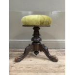 A Victorian mahogany revolving piano stool on tripod base with upholstered top
