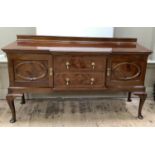 A 1920s mahogany breakfront sideboard having a short raised back above two drawers to the centre