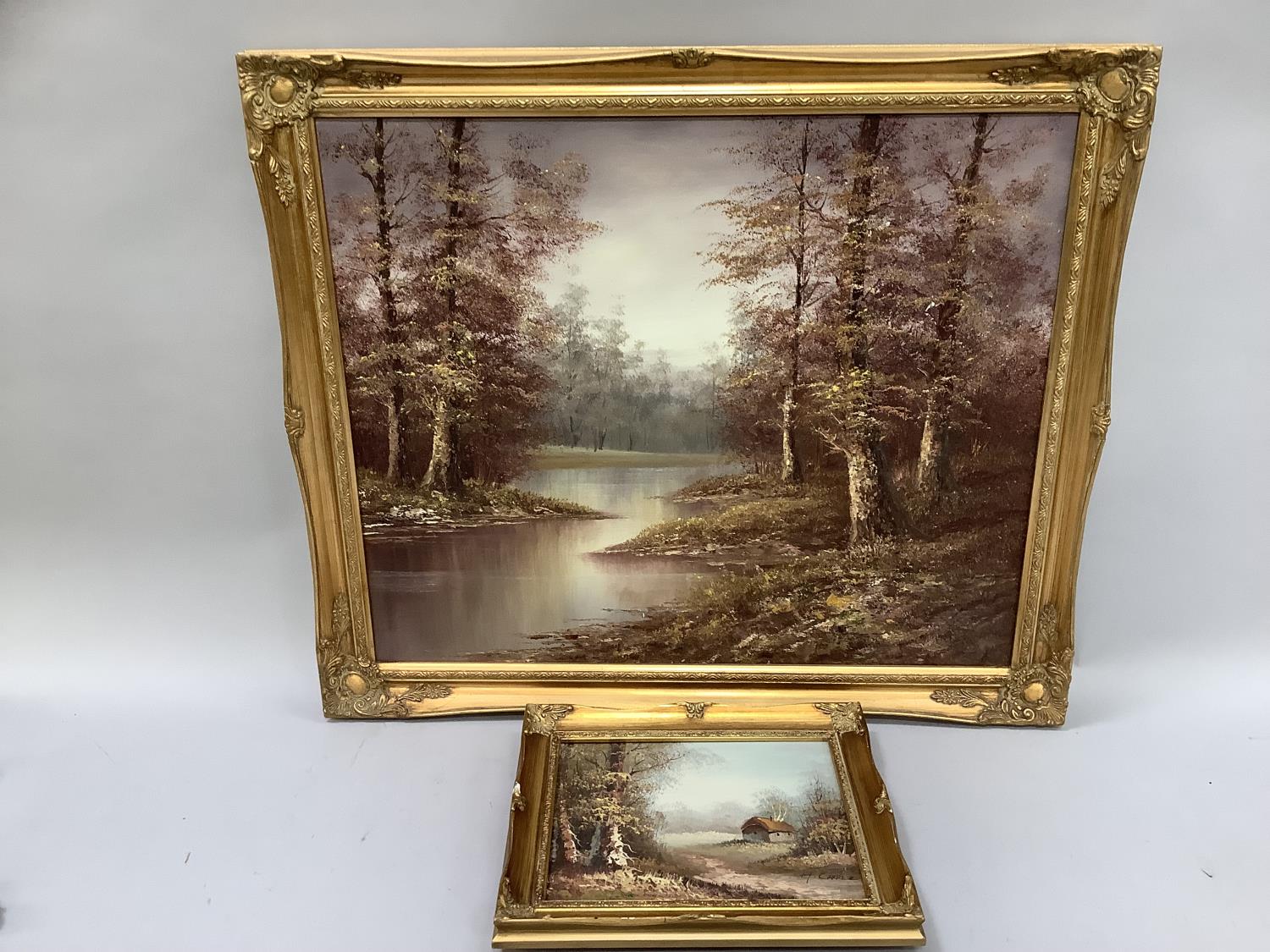 A river and woodland landscape, oil on canvas, indistinctly signed to lower right, 51cm by 61cm