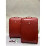 A pair of Roc red hard shell suitcases, on wheels with pull up handles