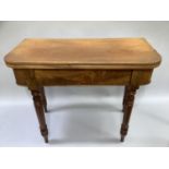 A 19th century mahogany fold over tea table on turned legs