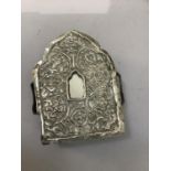 A Tibetan Buddhist Ghau box or portable shrine having a white base metal face embossed with