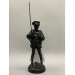A late 19th / early 20th century black finished metal figure of a young boy with fishing rod