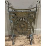 An Art Nouveau planished brass fire screen, the panel of pierced stylised plant form design, 53cm