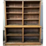 A set of oak open bookshelves having moulded uprights and on plinth base, the lower section having
