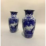 A pair of early 20th century Japanese vases painted in blue and white with rocks issuing blossom and