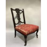 A late Victorian mahogany nursing chair having pierced splat and open back, upholstered seat and