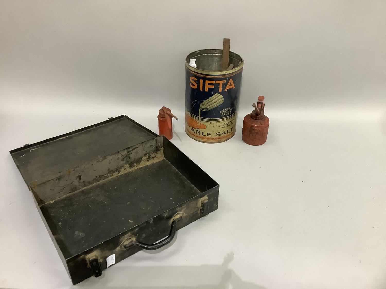 A vintage black metal document case together with two oil cans and a large Sifta table salt drum