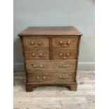 A mahogany chest having two twin dummy drawer cupboard and two drawers below, with brass ring