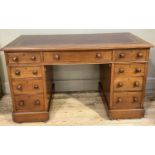A Victorian walnut kneehole desk having a burgundy leather incised writing surface having three