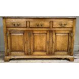 An oak dresser base of early 19th century design having three small drawers across, above three