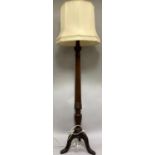 An early 20th century mahogany reeded and turned standard lamp on tripod base with shade