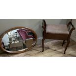 An early 20th century mahogany piano stool together with an oval wall mirror with bevelled glass