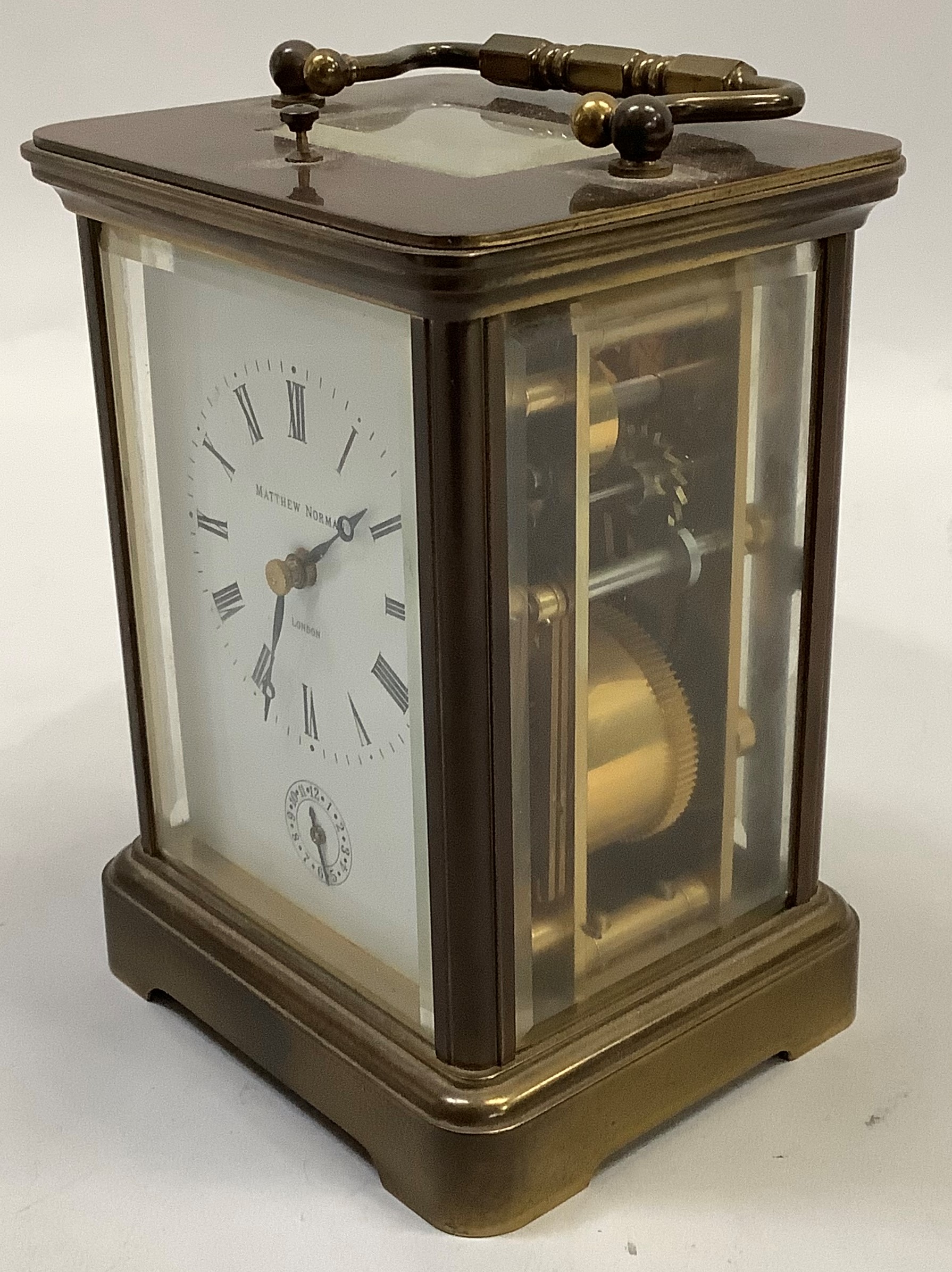 A carriage strike alarm clock by Matthew Norman in a brass case with five bevelled glass panels