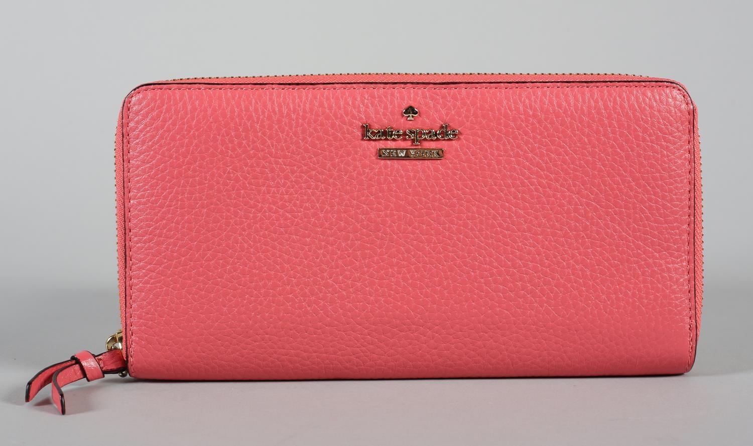 A Kate Spade twelve card zip round wallet in coral pink grained leather, condition: excellent,