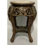A Chinese marble inset hardwood urn stand, pierced and carved apron and base joined by an under