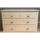 A painted pine low set chest of two short over two long drawers, 106cm wide by 65cm high, no feet
