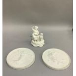 A pair of Royal Copenhagen parian plaques, circular, moulded in relief with angels carrying babes,