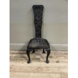 A Victorian oak carved spinning stool, the back and seat carved with sea serpents and on cabriole