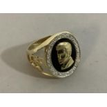 A signet ring in 9ct gold set to the oval head with a black onyx over laid with a gold cameo