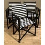 A set of three black framed director's chairs with black and white striped fabric seating