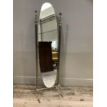 An oval cheval mirror on a gilt metal frame with cherub finials