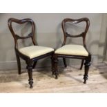 A pair of Victorian mahogany single chairs with foliate tie rail on inverted tulip and turned legs