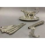 Six silver pistol handled tea knives, a parasol handle, (white metal tests as silver) embossed