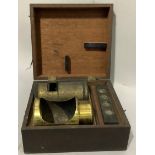 A lens, a lens cap and a slide with specimens in a mahogany box
