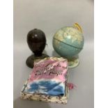 A vintage globe on printed metal stand together with a Bakelite lamp base and a New Zealand head
