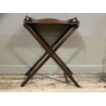 An early 20th century mahogany butler's tray and folding stand