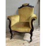 An Edwardian dark turned mahogany armchair having a pierced and carved cresting rail, arched