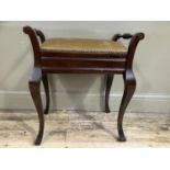 An early 20th century mahogany piano stool with upholstered lift up top