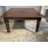 A Victorian mahogany dining table on turned legs with brass caps and casters, 152cm by 133cm