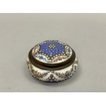 A 19th century Continental enamelled patch box, circular outline, the bleu celeste ground covered