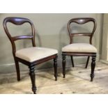 A pair of mahogany dining chairs with upholstered seats and on turned legs