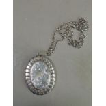 An old silver locket chased and engraved to the front and hung on a silver belcher chain,