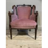 A Victorian walnut armchair having an encircling frame with foliate and shell carved cresting,