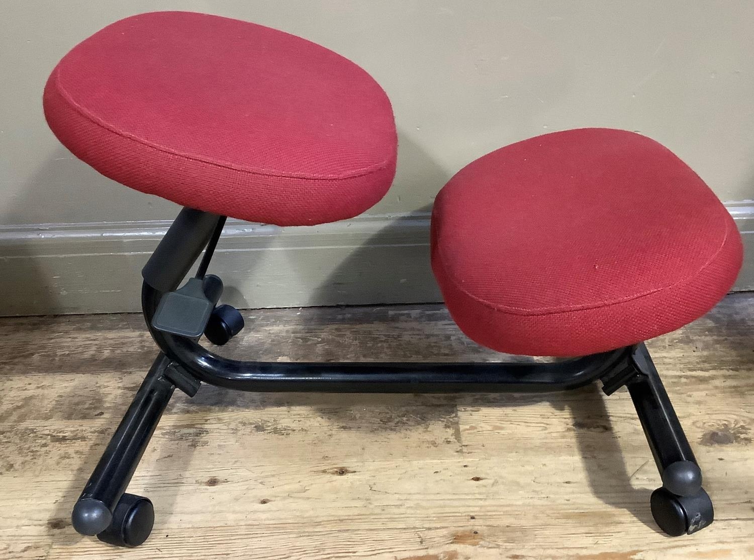 An ergonomic chair with red upholstered seat