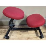 An ergonomic chair with red upholstered seat