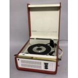 A vintage Regent Tone record player in red and cream case