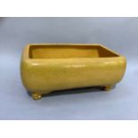 A Brannan pottery planter of Chinese style in egg-yolk yellow glaze, rectangular on scrolled feet