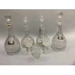 A pair of cut glass decanters with facetted globe stoppers with silver labels for port and sherry,
