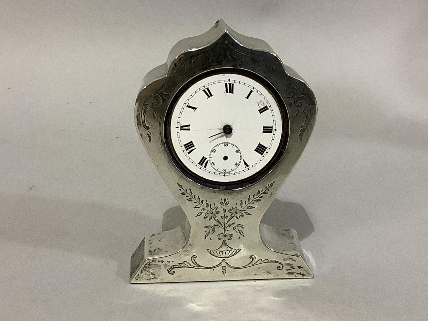 A silver faced boudoir clock, early 20th century engraved with foliate swags, the dial cracked,