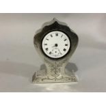 A silver faced boudoir clock, early 20th century engraved with foliate swags, the dial cracked,