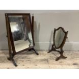 Two mahogany toilet mirrors, one of shield shape with boxwood stringing, the other rectangular