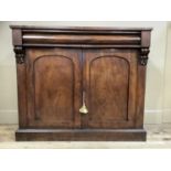 A mahogany cabinet having a cushion moulded frieze drawer above two arch indented panel doors, angle